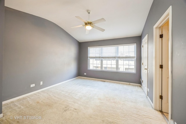 unfurnished room featuring light carpet, ceiling fan, vaulted ceiling, and baseboards