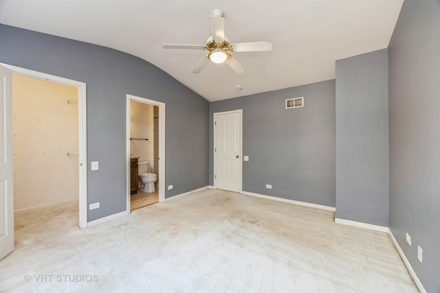 unfurnished bedroom with carpet, a closet, visible vents, vaulted ceiling, and baseboards