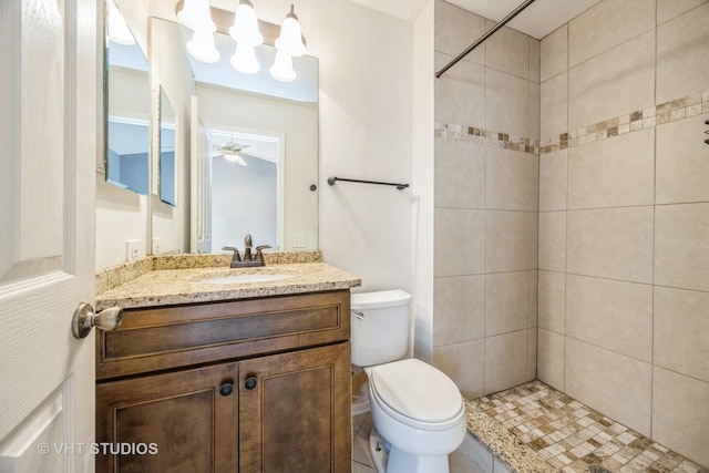 full bath with toilet, a tile shower, and vanity