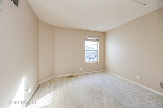 empty room with carpet floors, visible vents, and baseboards