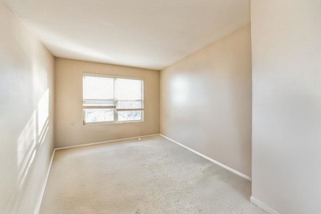 carpeted empty room with baseboards