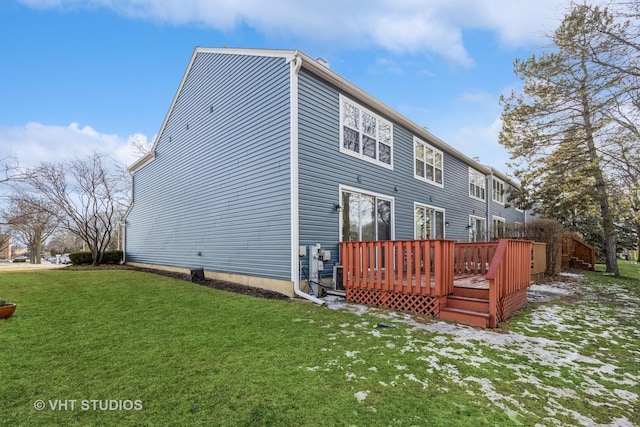 rear view of property featuring a lawn and a wooden deck