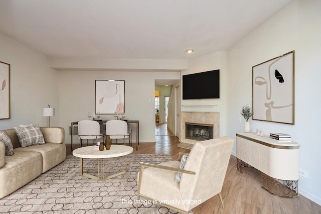 living room with a premium fireplace, wood finished floors, and baseboards