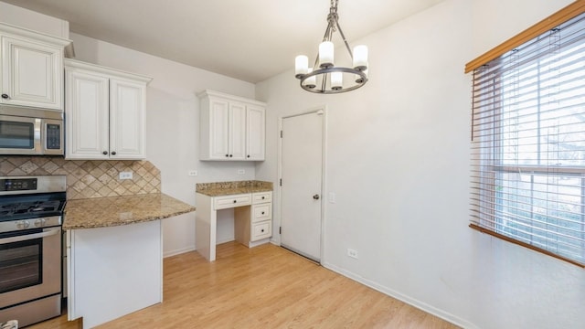 kitchen with light wood-type flooring, appliances with stainless steel finishes, decorative backsplash, and a wealth of natural light