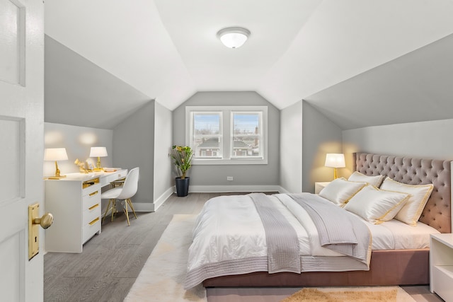 bedroom with lofted ceiling and light hardwood / wood-style flooring