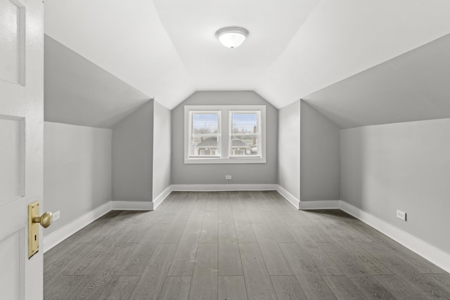 additional living space featuring lofted ceiling and light hardwood / wood-style flooring