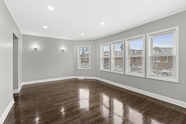 empty room with crown molding and dark hardwood / wood-style floors