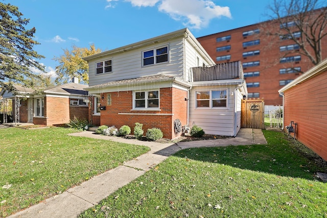 back of house featuring a balcony and a lawn