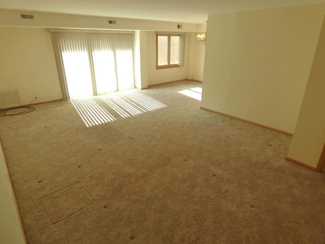 carpeted empty room with a chandelier