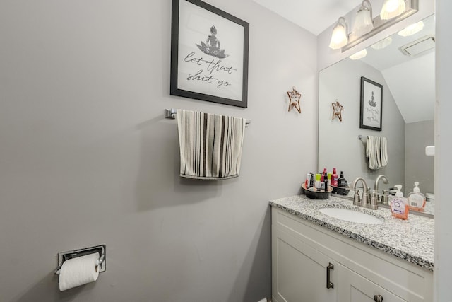 bathroom featuring vanity and lofted ceiling