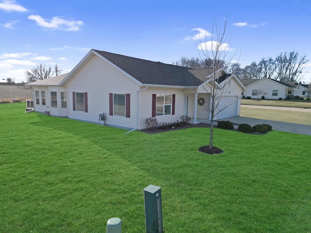 ranch-style house featuring a garage and a front lawn