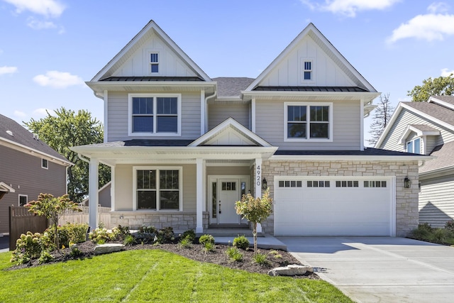 view of front facade with a garage, a porch, and a front lawn