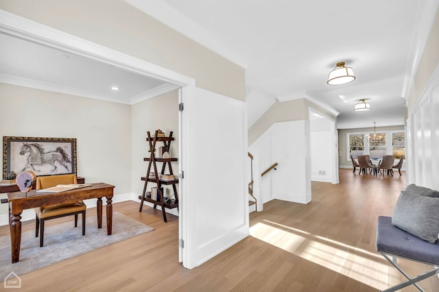 living area featuring ornamental molding, an inviting chandelier, and light hardwood / wood-style floors