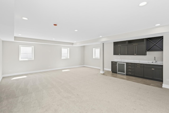 bar featuring carpet floors, beverage cooler, a raised ceiling, and sink