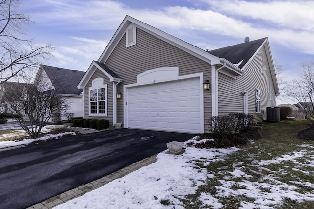 view of front of home with central AC unit and a garage