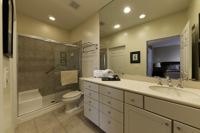 bathroom with tile patterned flooring, an enclosed shower, vanity, and toilet