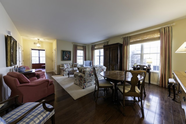 dining area with a wealth of natural light and dark hardwood / wood-style floors