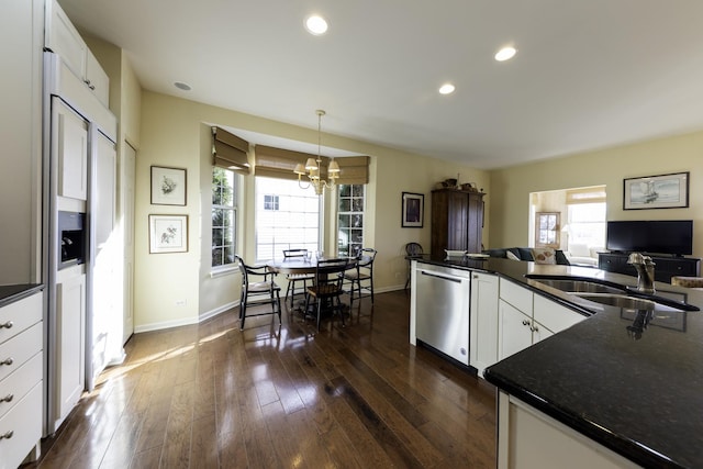 kitchen with pendant lighting, white cabinetry, sink, dark hardwood / wood-style flooring, and stainless steel dishwasher