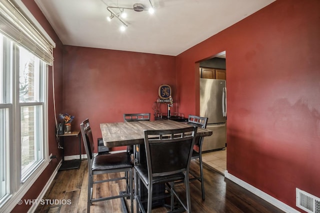 dining area featuring a healthy amount of sunlight and dark hardwood / wood-style floors