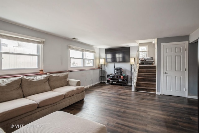 living room with dark wood-type flooring and a wealth of natural light