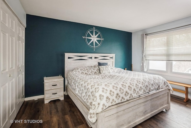 bedroom with dark wood-type flooring and a closet