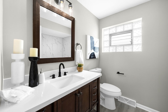 bathroom with hardwood / wood-style flooring, vanity, and toilet