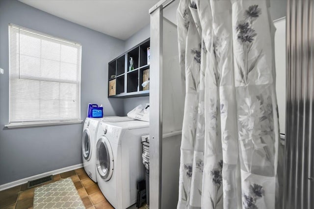 clothes washing area featuring washer and dryer and tile patterned floors