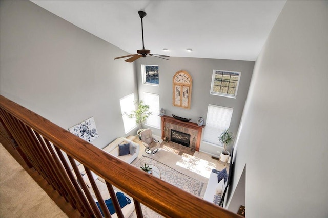 stairway with ceiling fan, carpet flooring, and a high ceiling