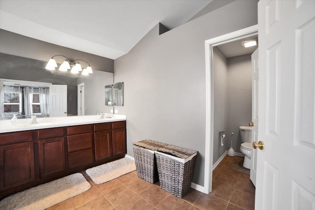 bathroom with tile patterned floors, vanity, toilet, and vaulted ceiling