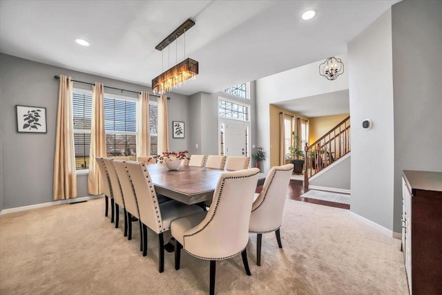 dining area with light carpet and a notable chandelier