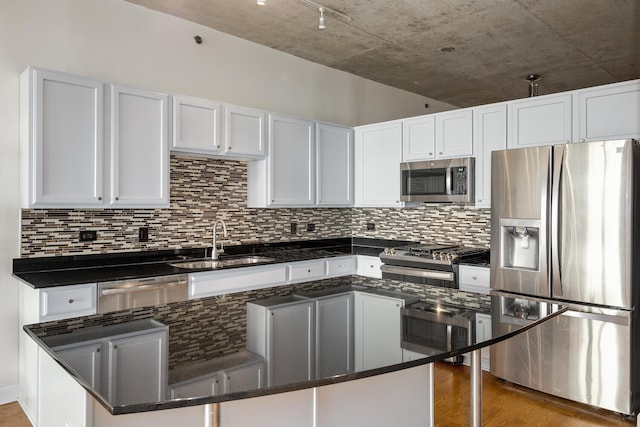 kitchen with hardwood / wood-style flooring, appliances with stainless steel finishes, sink, and white cabinets