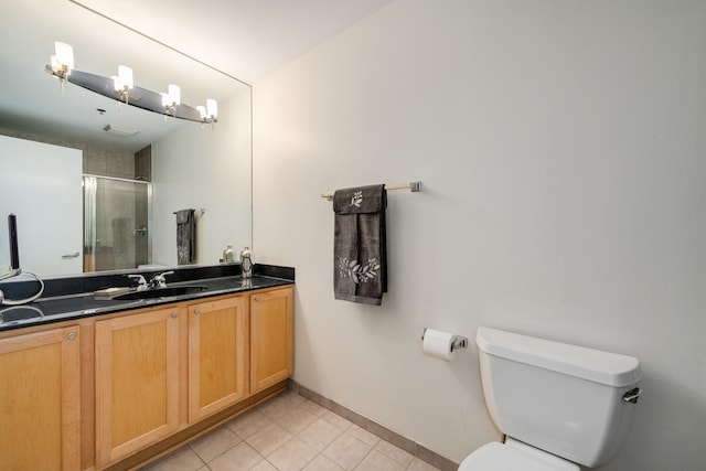 bathroom with tile patterned floors, toilet, a shower with door, and vanity