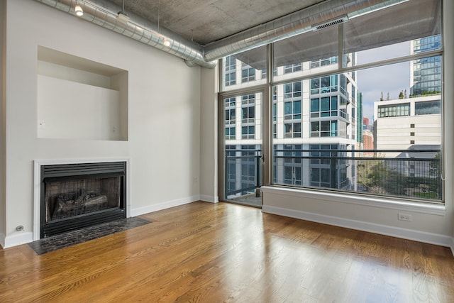 unfurnished living room featuring a wealth of natural light and wood-type flooring