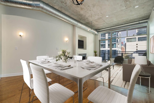 dining room with hardwood / wood-style flooring and a wall of windows