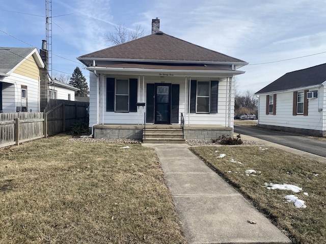 bungalow featuring covered porch and a front yard