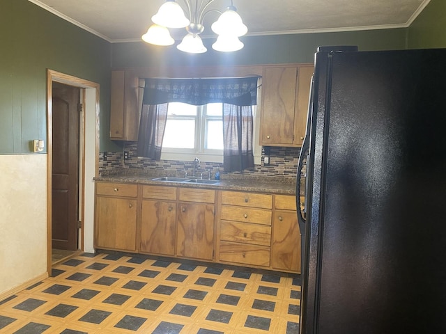 kitchen with sink, black refrigerator, backsplash, a notable chandelier, and decorative light fixtures