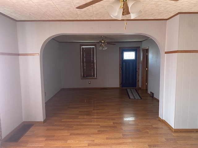 corridor with hardwood / wood-style flooring and wooden walls