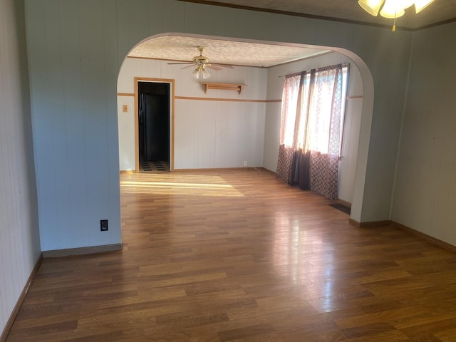 empty room with dark hardwood / wood-style floors and ceiling fan