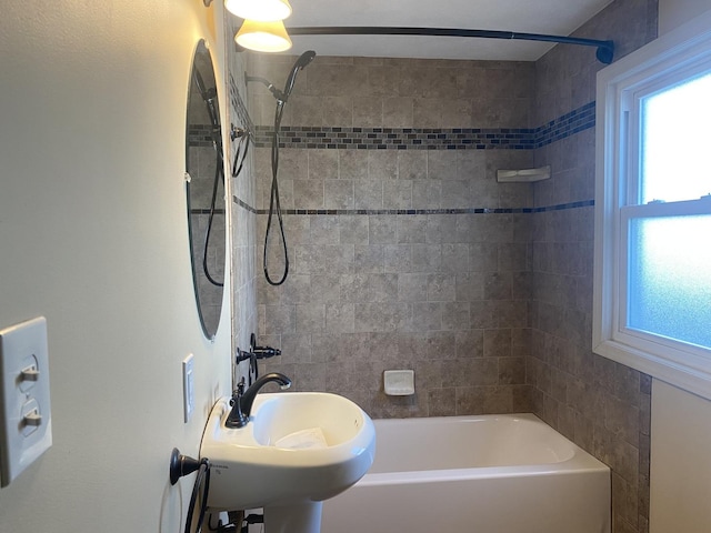 bathroom featuring tiled shower / bath combo and sink