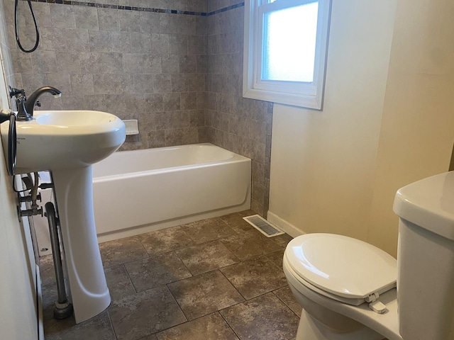 bathroom with toilet and washtub / shower combination