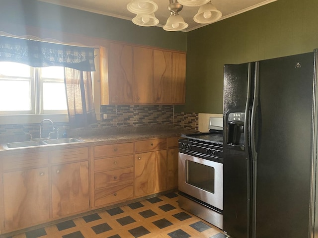 kitchen featuring sink, backsplash, a notable chandelier, black fridge with ice dispenser, and stainless steel range with gas cooktop