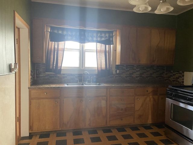 kitchen featuring stainless steel gas range, sink, and decorative backsplash