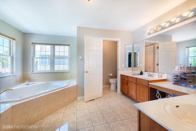 bathroom with tile patterned floors, toilet, vanity, and tiled tub