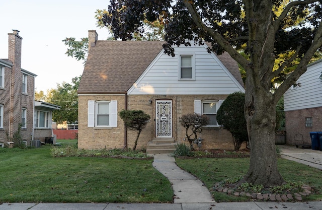 view of front of property with cooling unit and a front lawn