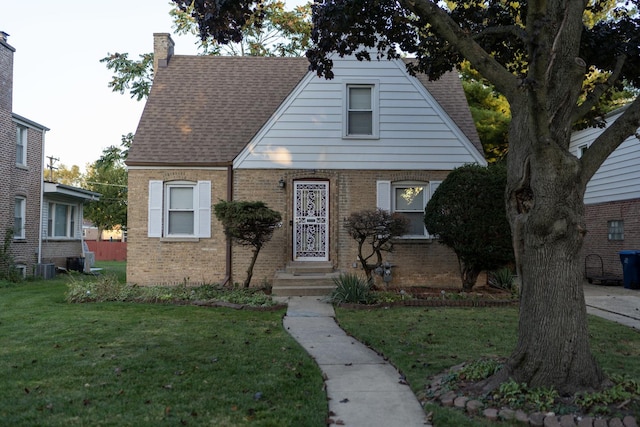 view of front facade with a front lawn and central air condition unit