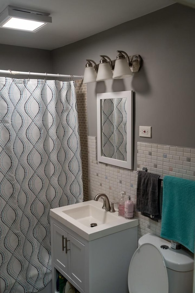 bathroom featuring tile walls, vanity, toilet, and a shower with shower curtain