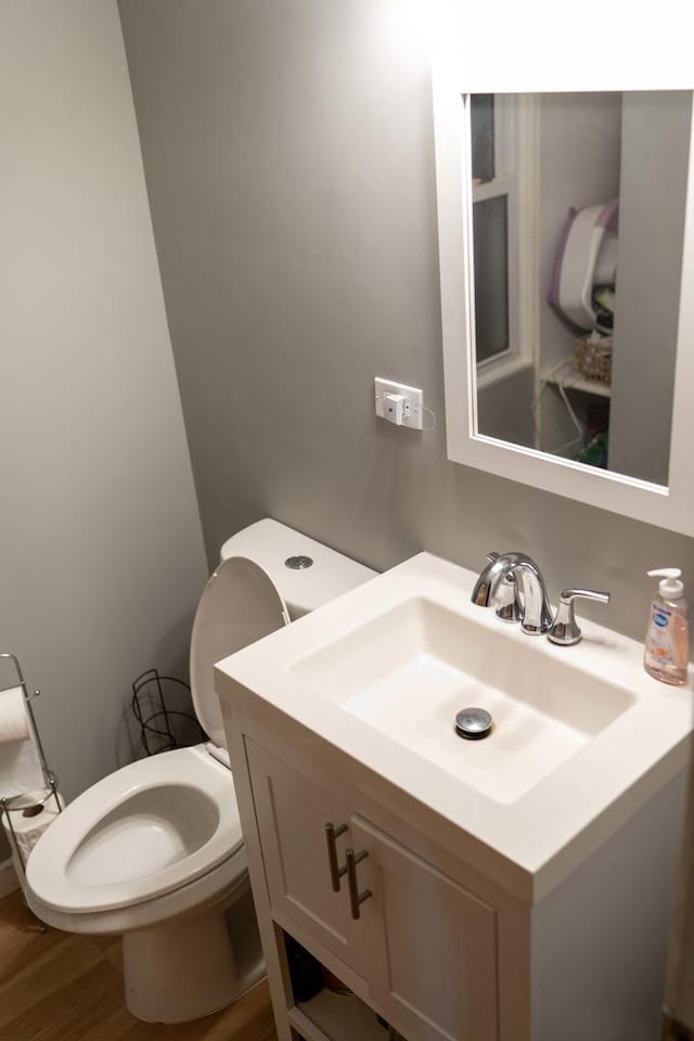 bathroom featuring vanity, hardwood / wood-style floors, and toilet