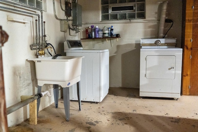 clothes washing area with sink, electric panel, and washer and clothes dryer