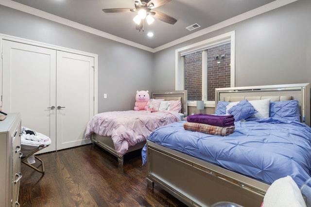 bedroom featuring crown molding, ceiling fan, dark hardwood / wood-style flooring, and a closet