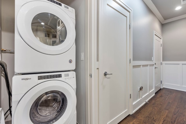 clothes washing area with stacked washer / dryer, ornamental molding, and dark hardwood / wood-style floors